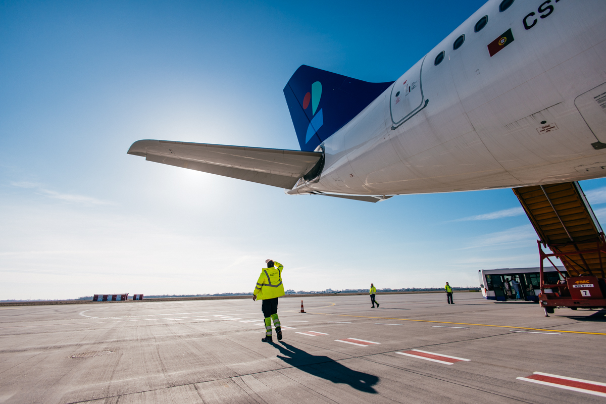Technician walking under an aircraft wing on the apron